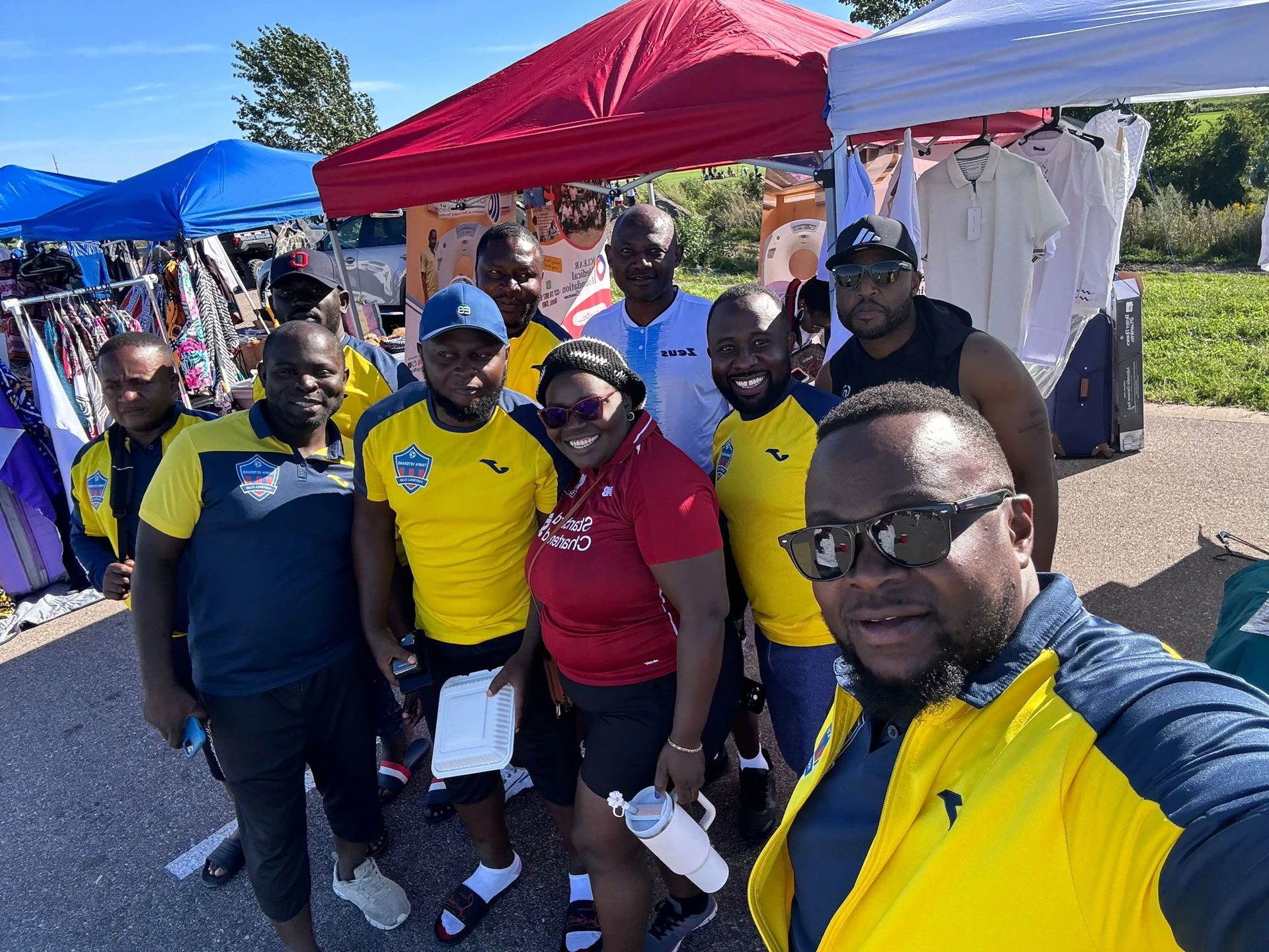 Club members taking a group photo beside event tents