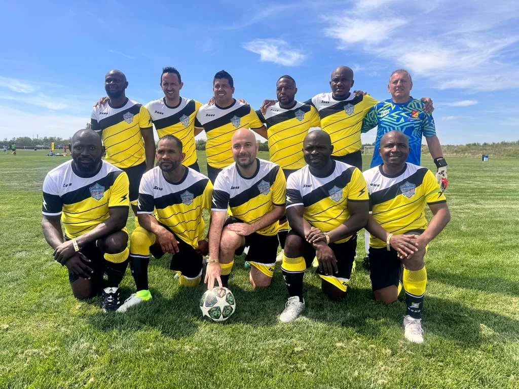 Football team posing together in yellow and black kits
